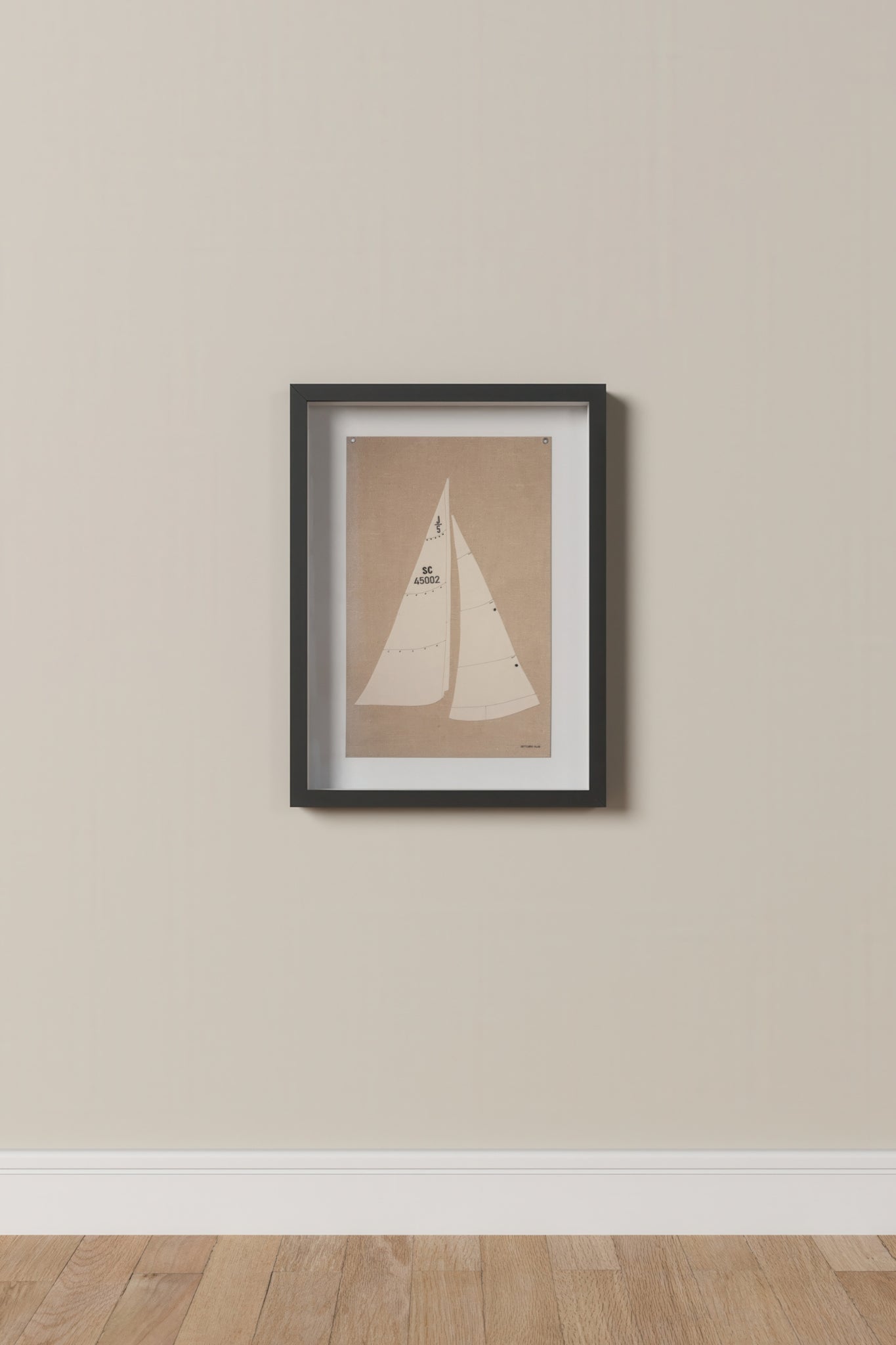 Framed artwork of a sailboat on a beige wall.