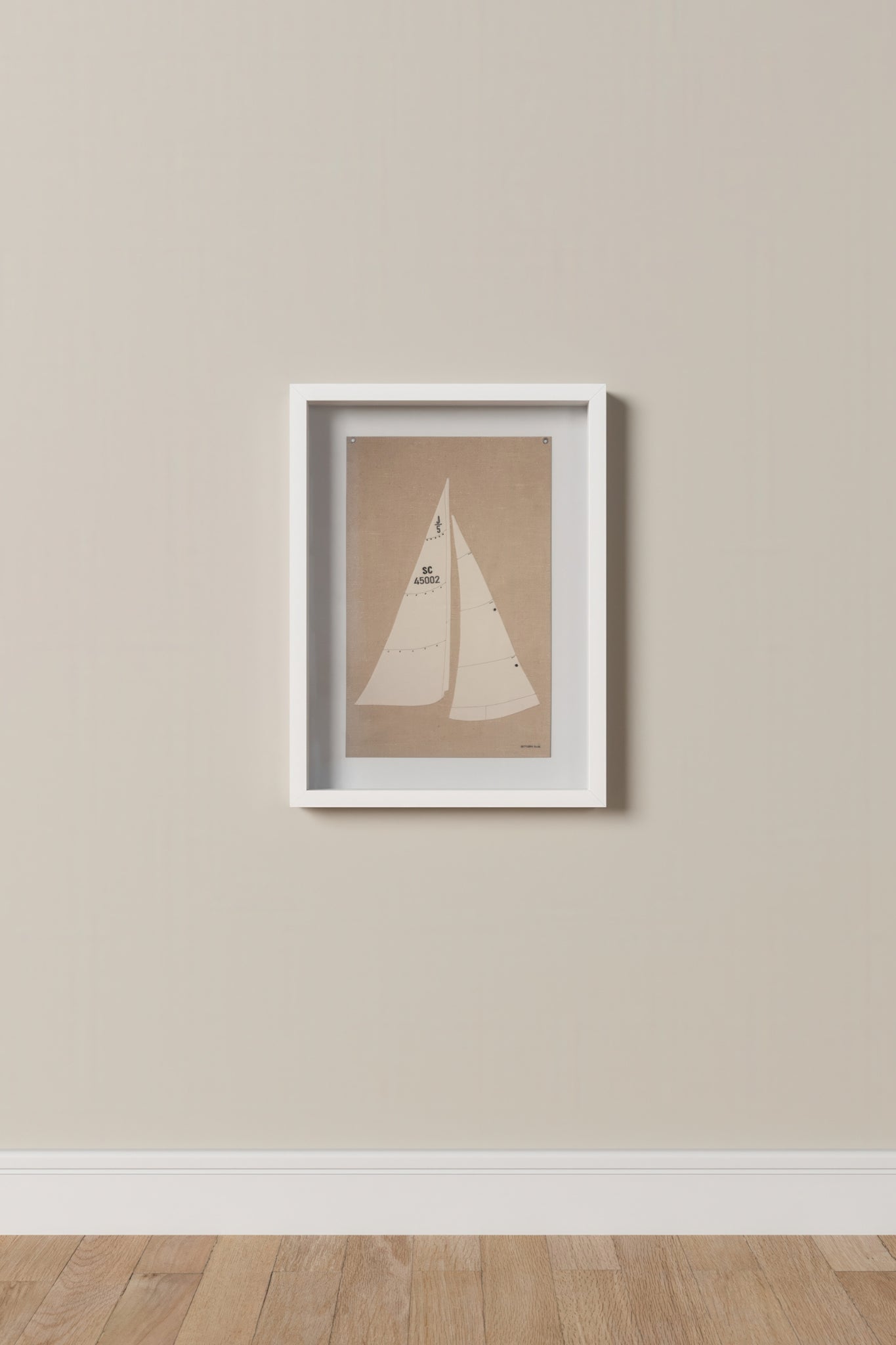 Framed artwork of a sailboat on a beige wall.