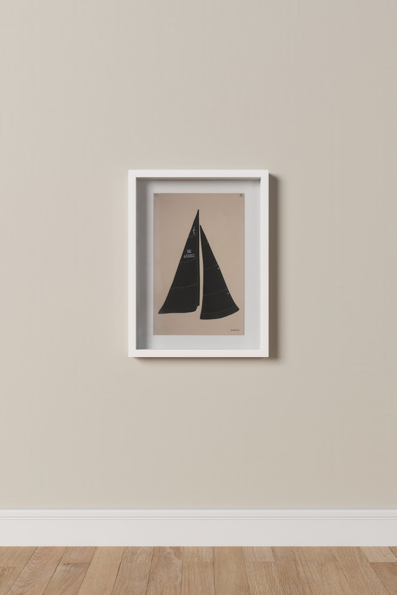 Framed artwork of a sailboat on a beige wall.